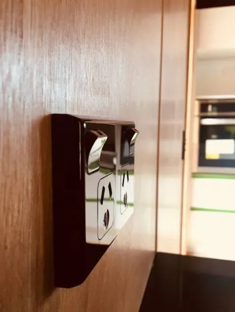Black and chrome double power point on a timber wall