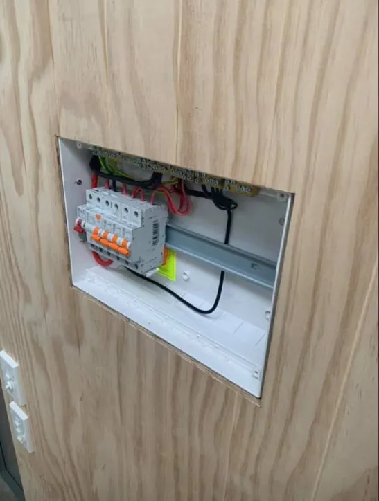 Switchboard set neatly into a plywood wall