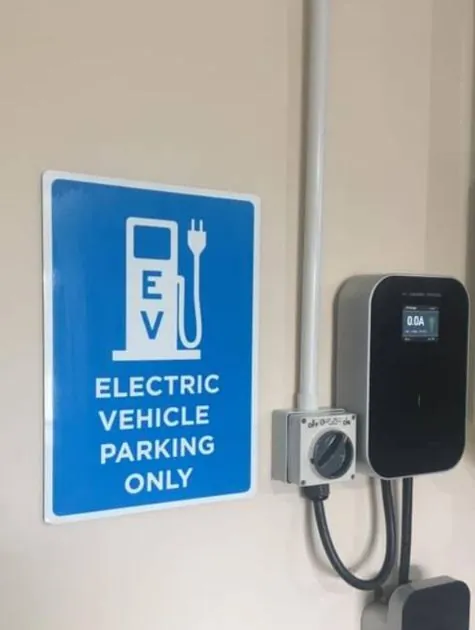 Wall charger beside an electric vehicle parking sign